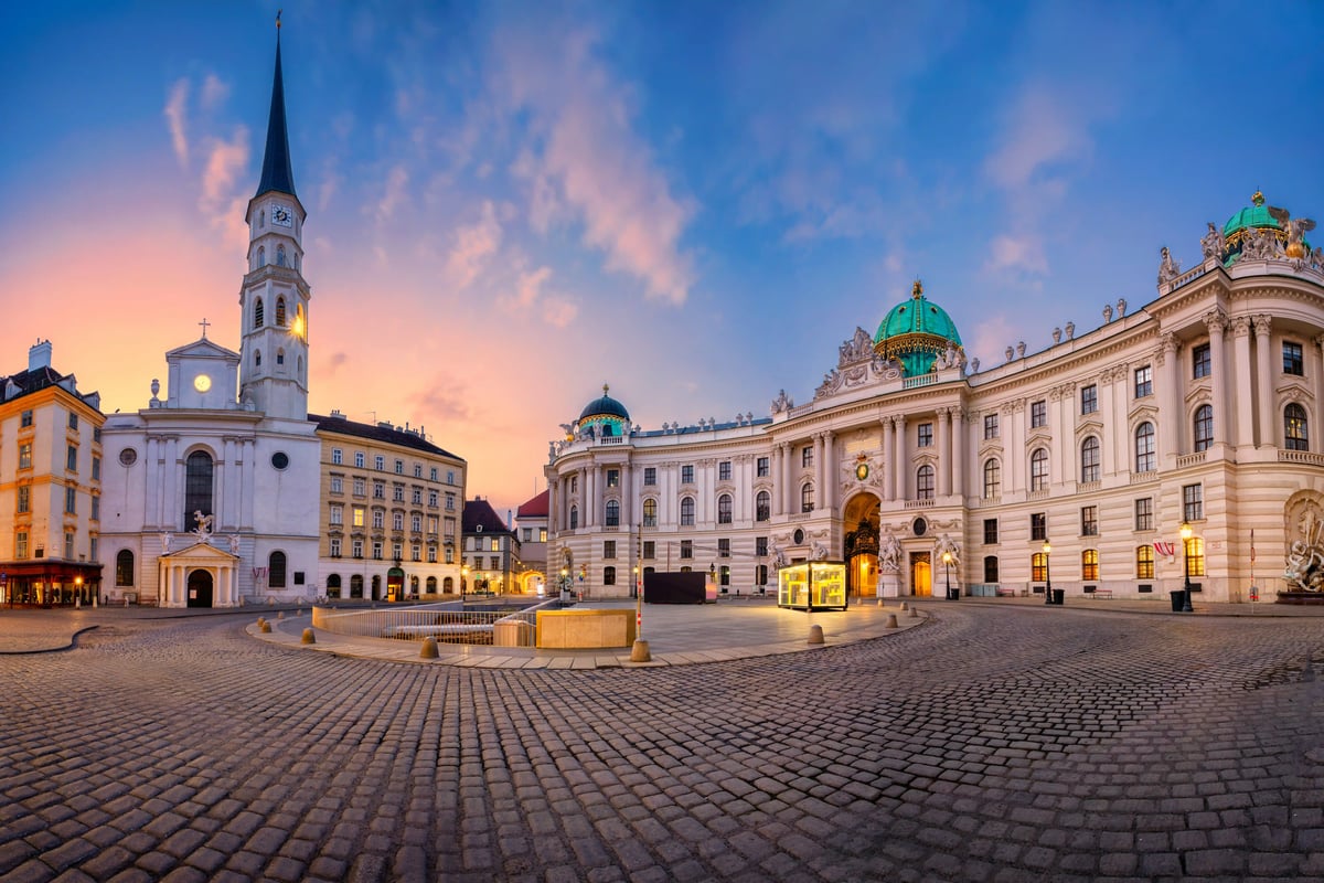 Michaelerplatz à Vienne avec l’église Saint-Michel et la Hofburg au crépuscule.