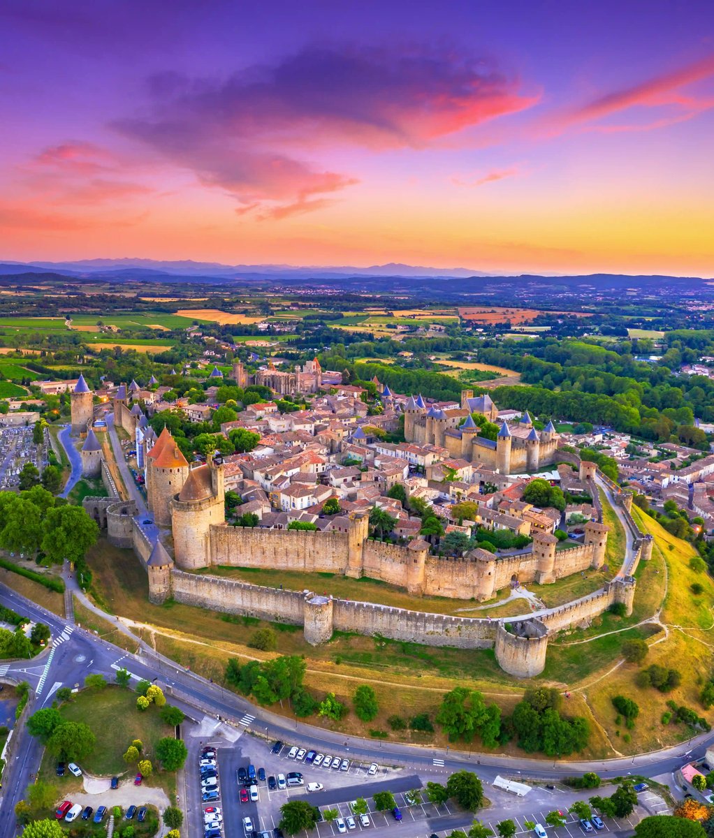 Luftaufnahme der mittelalterlichen Burgstadt Carcassonne mit Stadtmauer und Türmen bei farbigem Abendhimmel