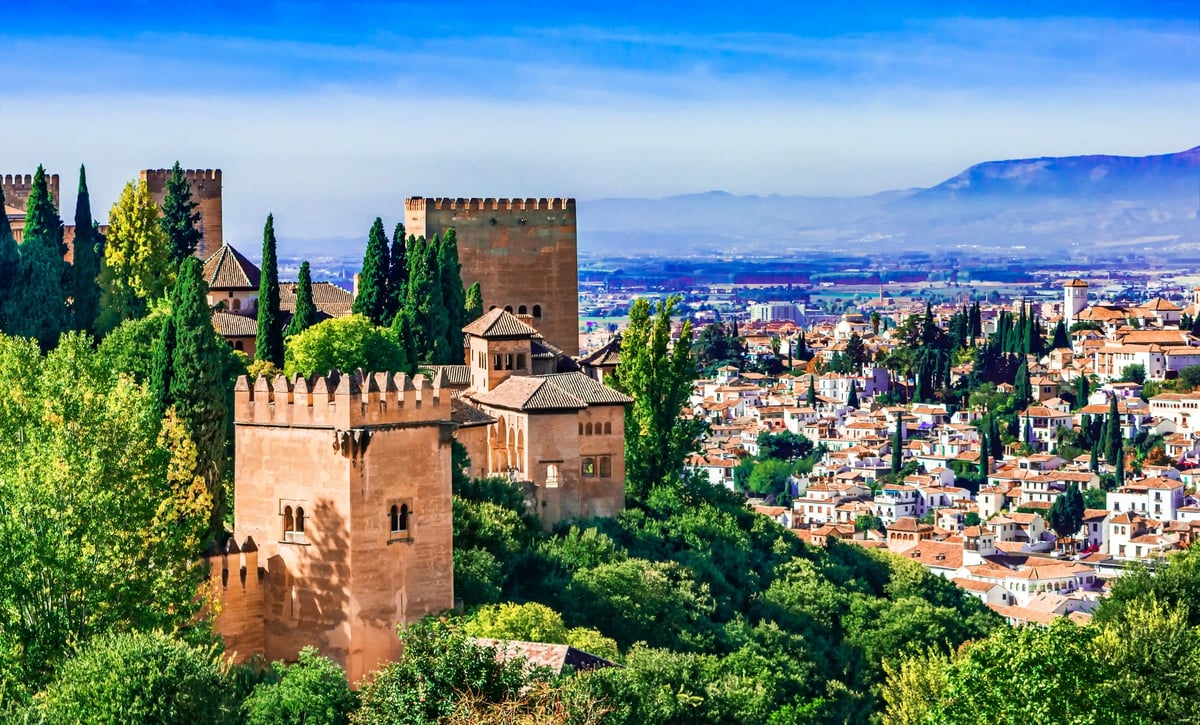 Blick auf die Alhambra mit Gärten und Türmen über der Stadt Granada
