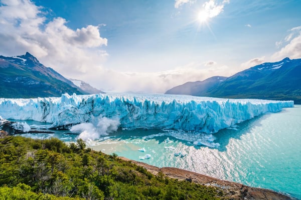 Gletscherfront des Perito Moreno mit abbrechendem Eis in tuerkisfarbenem Wasser