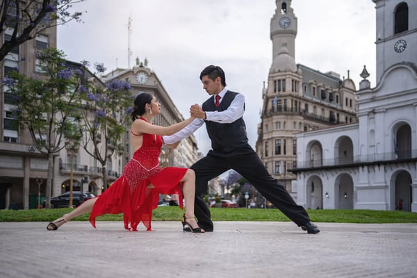 Paar tanzt Tango auf einer Strasse vor historischen Gebäuden in Buenos Aires