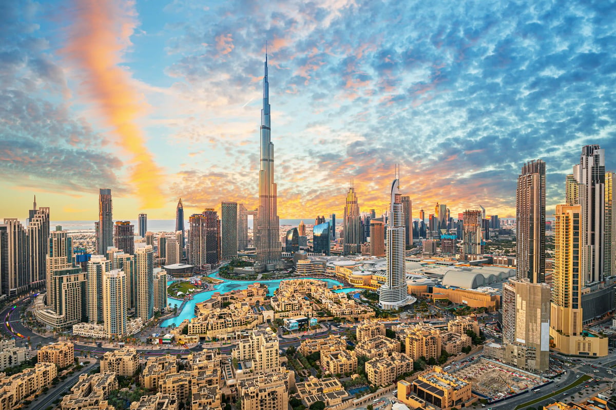 Weitläufiges Stadtpanorama von Dubai mit dem Burj Khalifa bei farbigem Abendhimmel