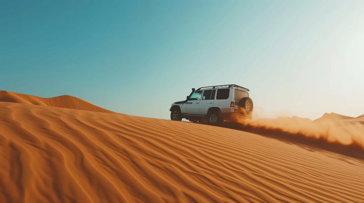 Geländewagen fährt durch goldene Sanddünen der arabischen Wüste bei klarem Himmel