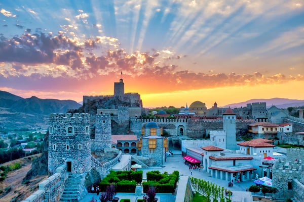 Mittelalterliche Festung in Georgien bei Sonnenuntergang mit warmem Licht und dramatischem Himmel