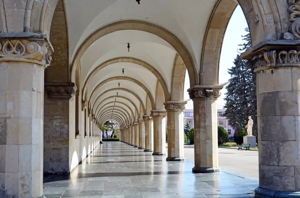 Langer Arkadengang mit symmetrischen Steinbögen und glänzendem Boden in einer georgischen Stadt