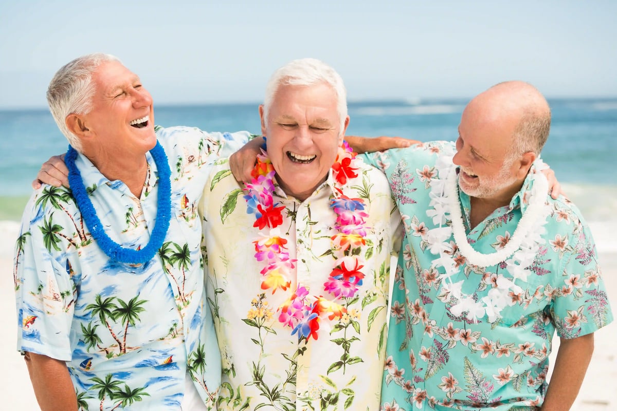 Drei ältere und lachende Senioren auf Hawaii