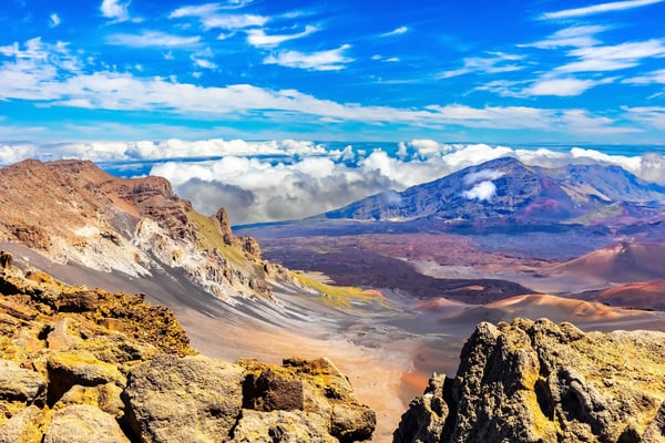 Vulkanlandschaft im Haleakala Nationalpark mit Krater, Felsformationen und Wolken über den Bergen