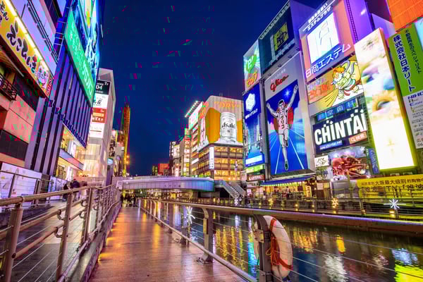 Belebte Strasse in Dotonbori Osaka mit Neonlichtern und Reklametafeln am Kanal