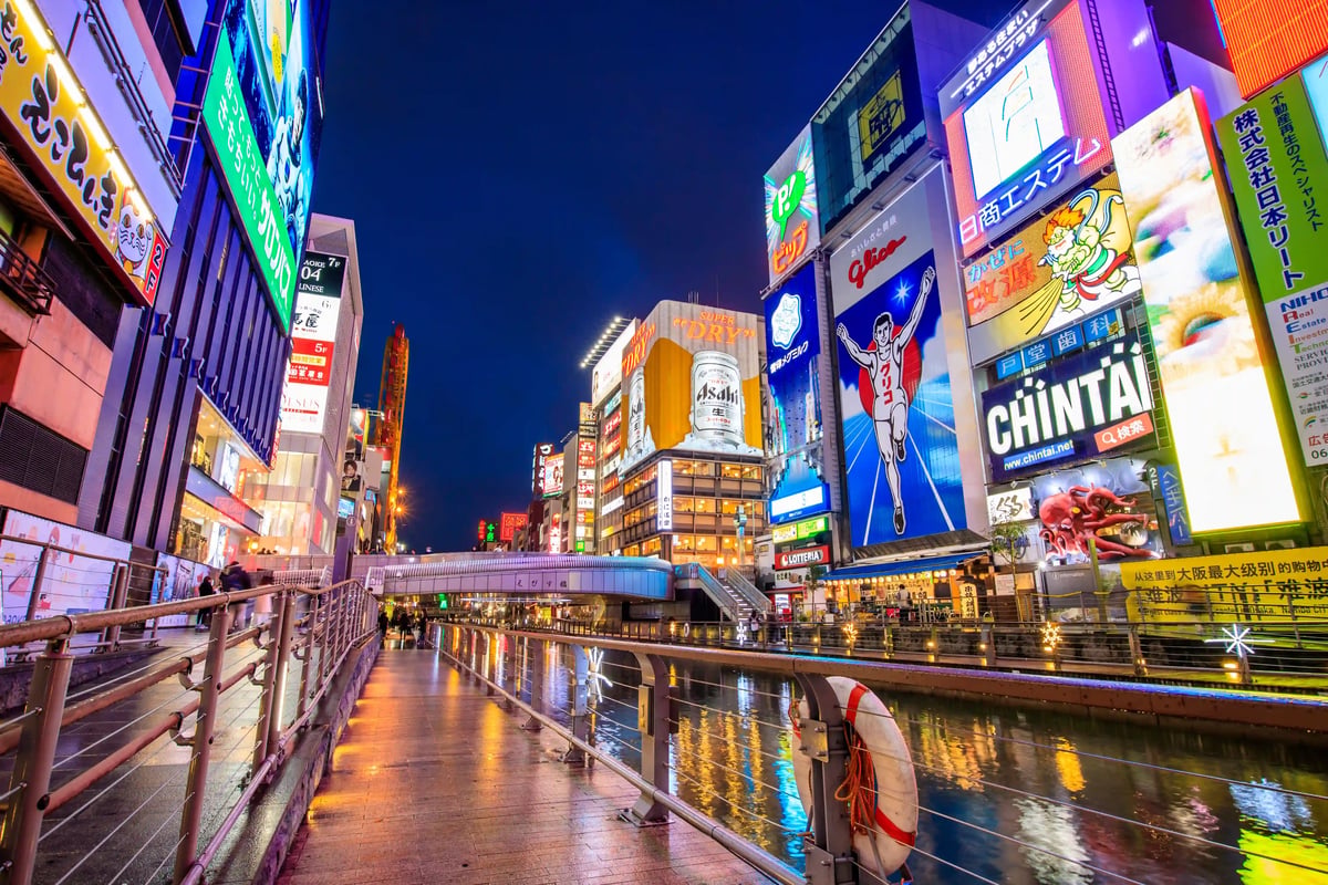 Belebte Strasse in Dotonbori Osaka mit Neonlichtern und Reklametafeln am Kanal