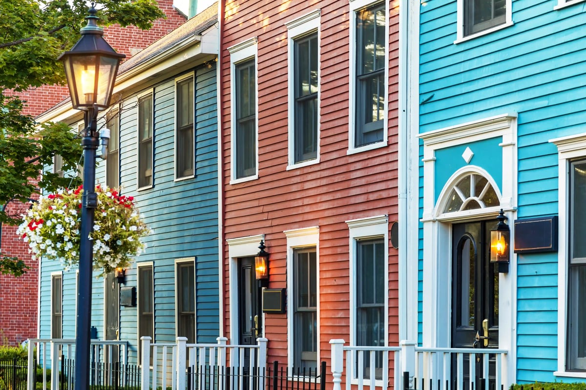 Farbenfrohe historische Häuser in Charlottetown mit Holzfassaden, Strassenlaterne und Blumenampel bei Tageslicht