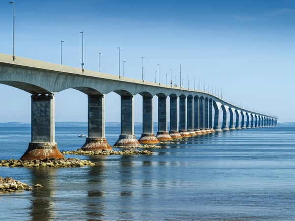 Perspektivische Ansicht der Confederation Bridge mit Pfeilern im Wasser und ruhiger Meeresoberfläche