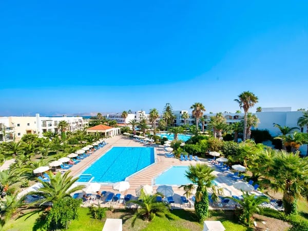 Grosszügige Resortanlage mit mehreren Pools, Liegestühlen, Palmen und gepflegtem Garten