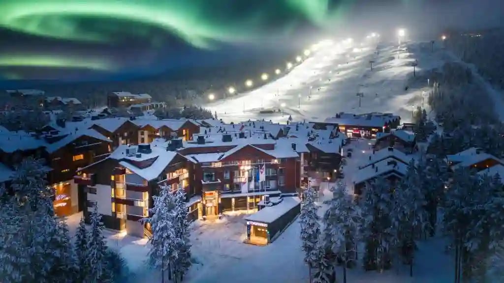 Winterliches Hotelresort in Levi mit beleuchteter Skipiste bei Nacht