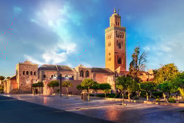 Koutoubia Moschee in Marrakesch mit hohem Minarett vor blauem Himmel und gepflegter Gartenanlage