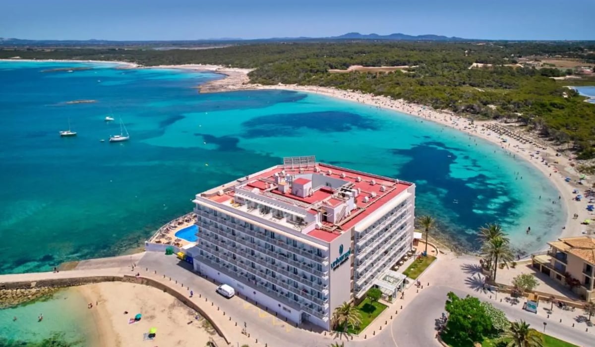 Grosses Strandhotel an einer türkisfarbenen Meeresbucht mit Sandstrand und Pinienlandschaft auf Mallorca