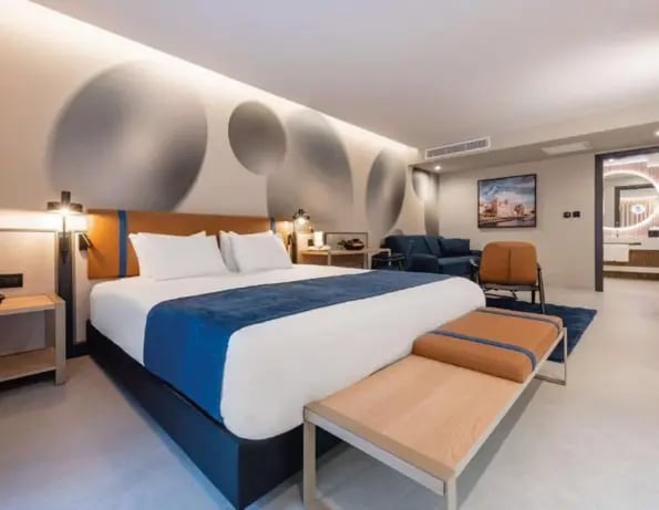 Modernes Hotelzimmer auf Malta mit Doppelbett, Sitzbereich und stilvollem Design