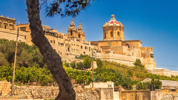 Blick auf Mdina mit historischer Stadtmauer, Kirchenkuppeln und Steinbauten