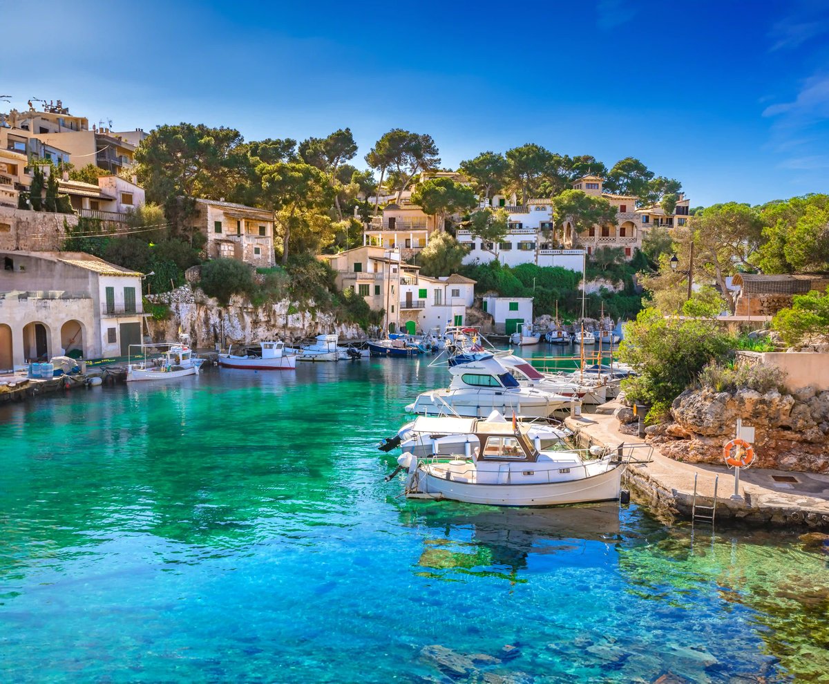 Hafen von Cala Figuera mit Booten, türkisfarbenem Wasser und Häusern am Hang