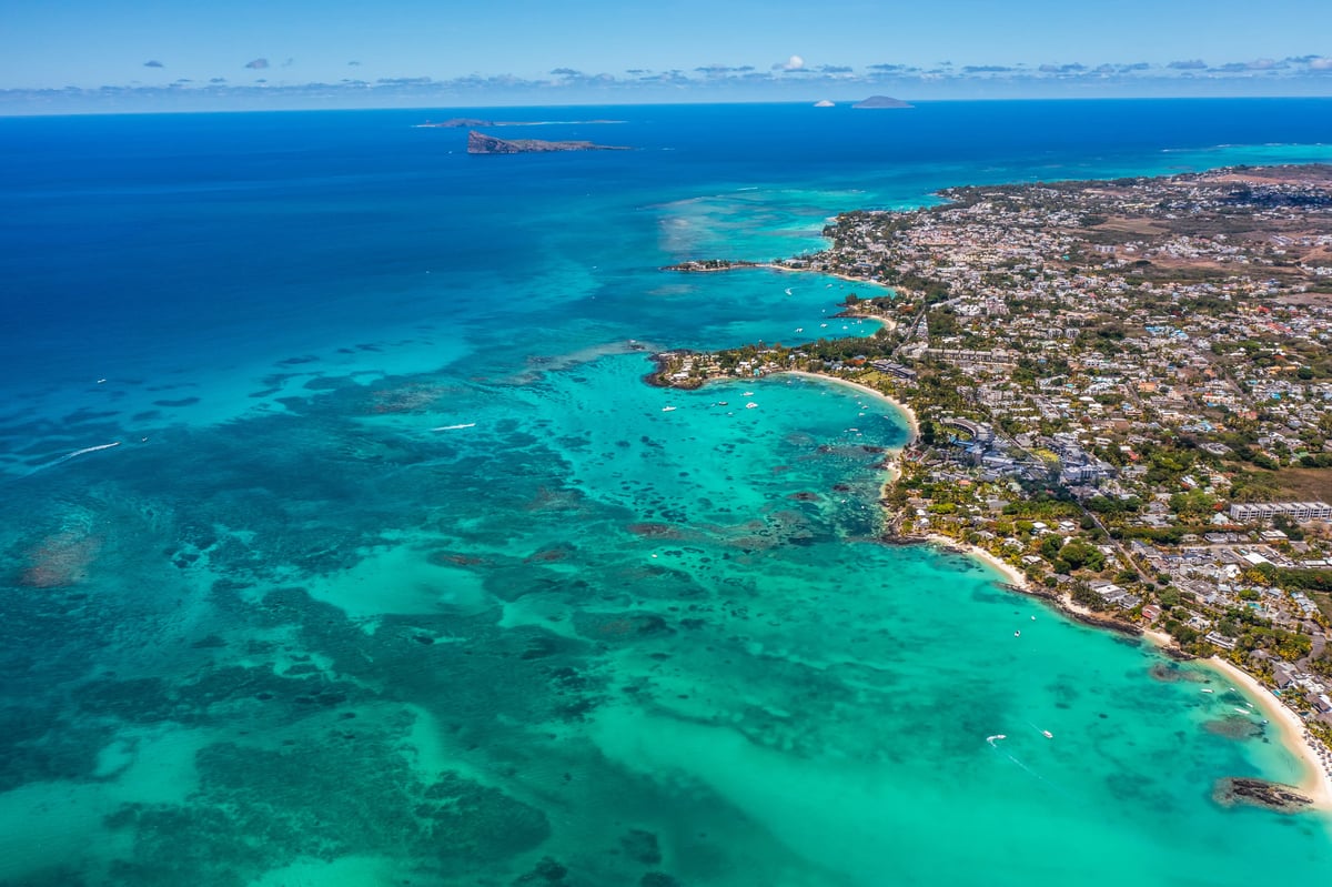 Luftaufnahme von Grand Baie mit türkisfarbenem Meer, Küstenlinie und dicht bebautem Küstenort