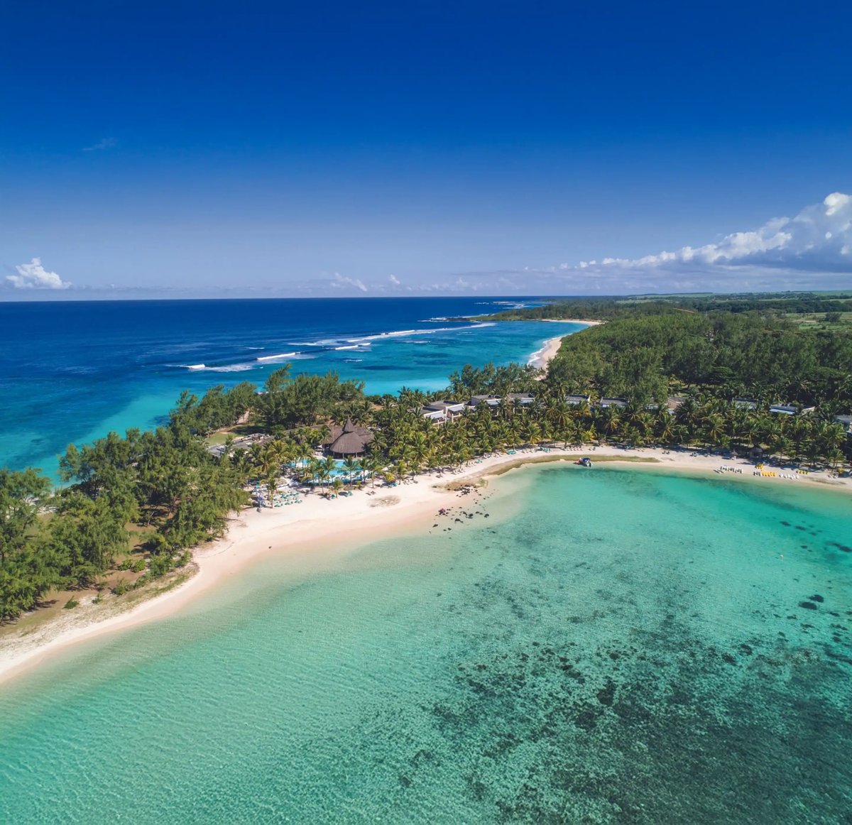 Luftaufnahme eines Resorts an einer geschwungenen Lagune mit weissem Sandstrand und Palmen