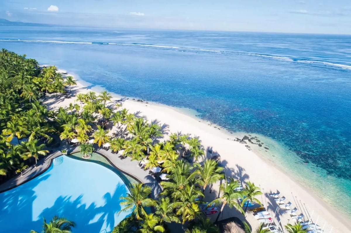 Strandresort mit Pool, Palmen und hellem Sandstrand an einer ruhigen Lagune