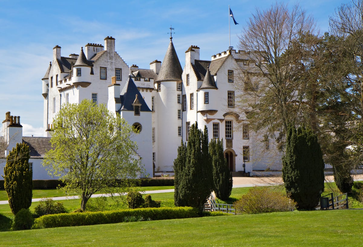 Ein weisses Schloss mit Türmen und gepflegtem Garten