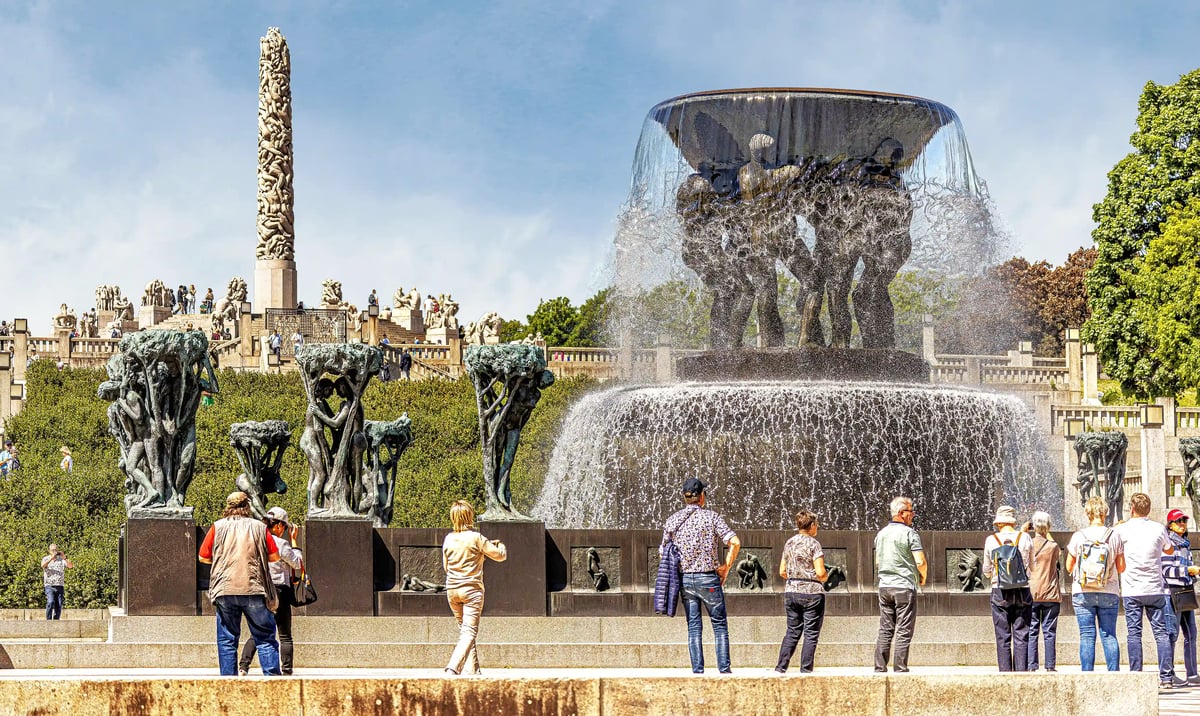 Skulpturen und Brunnenanlage im Vigeland Park in Oslo mit Besuchern an einem sonnigen Tag