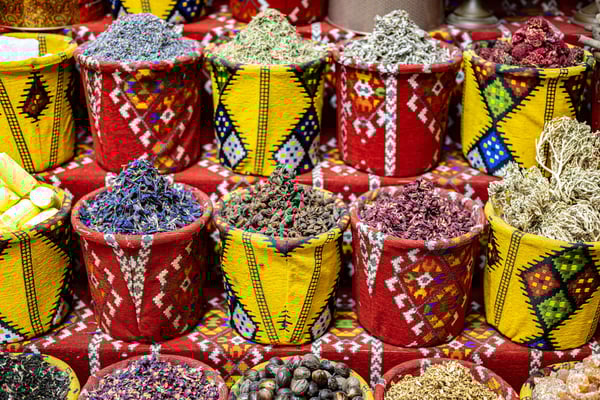 Bunte Körbe mit getrockneten Gewürzen, Kräutern und Blüten auf einem traditionellen Markt im Oman