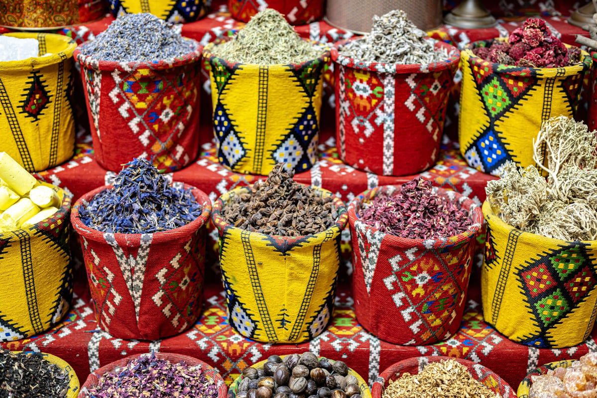 Bunte Körbe mit getrockneten Gewürzen, Kräutern und Blüten auf einem traditionellen Markt im Oman