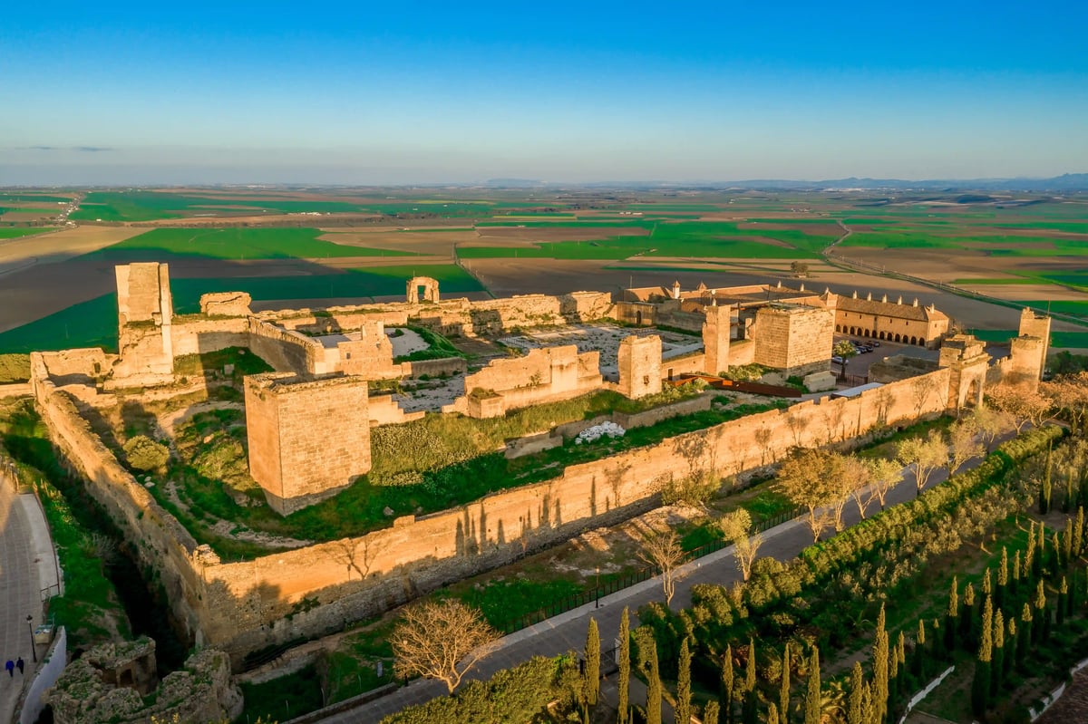 Historische Festungsanlage mit Türmen und Mauern in weiter Landschaft mit grünen Feldern