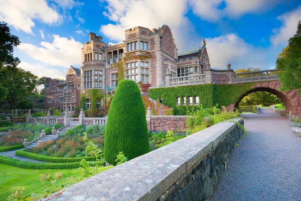 Historisches Schloss Tjolöholm mit gepflegtem Garten und Steinbrücke im Vordergrund