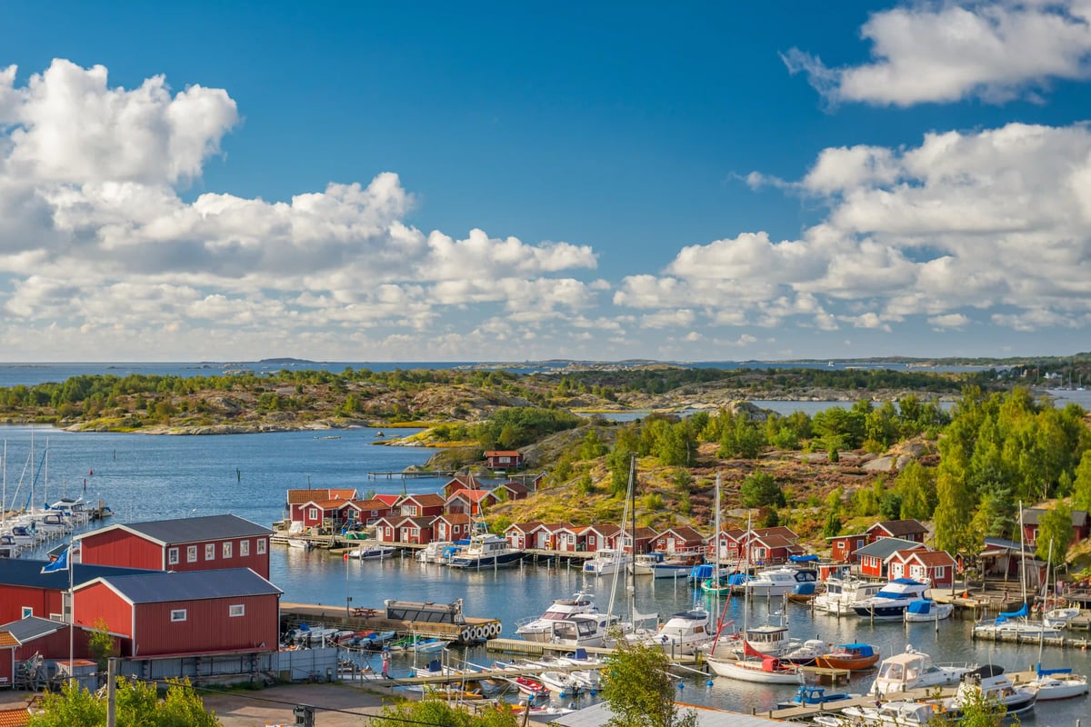 Schwedische Westküste mit roten Holzhäusern Bootshafen und felsiger Schärenlandschaft