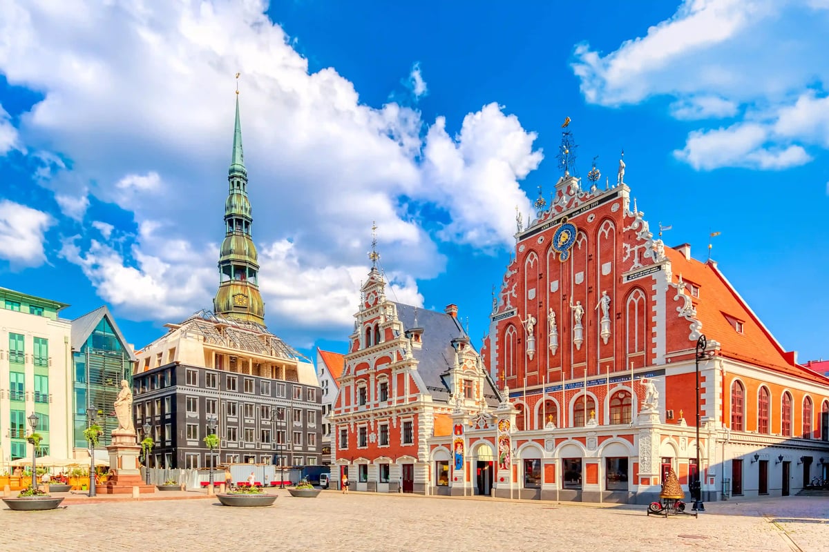 Rathausplatz in Riga mit historischer Architektur, Kirchturm und farbigen Fassaden