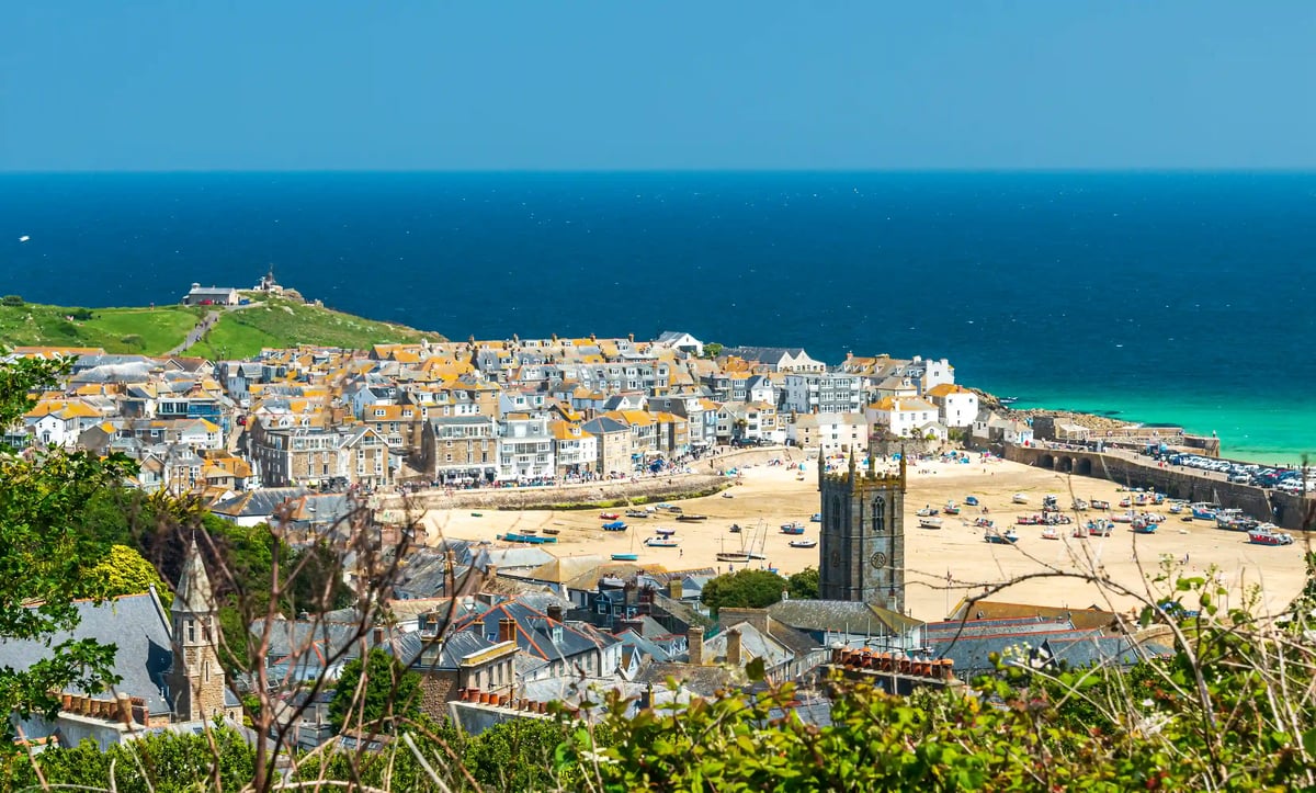 Blick auf St Ives mit Sandstrand, Hafenbecken, Booten und dicht bebautem Ortskern