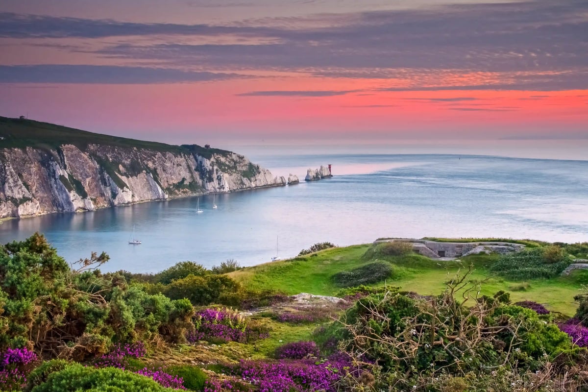 Weitläufiges Küstenpanorama mit hohen Klippen, grünem Grasland und offenem Meer
