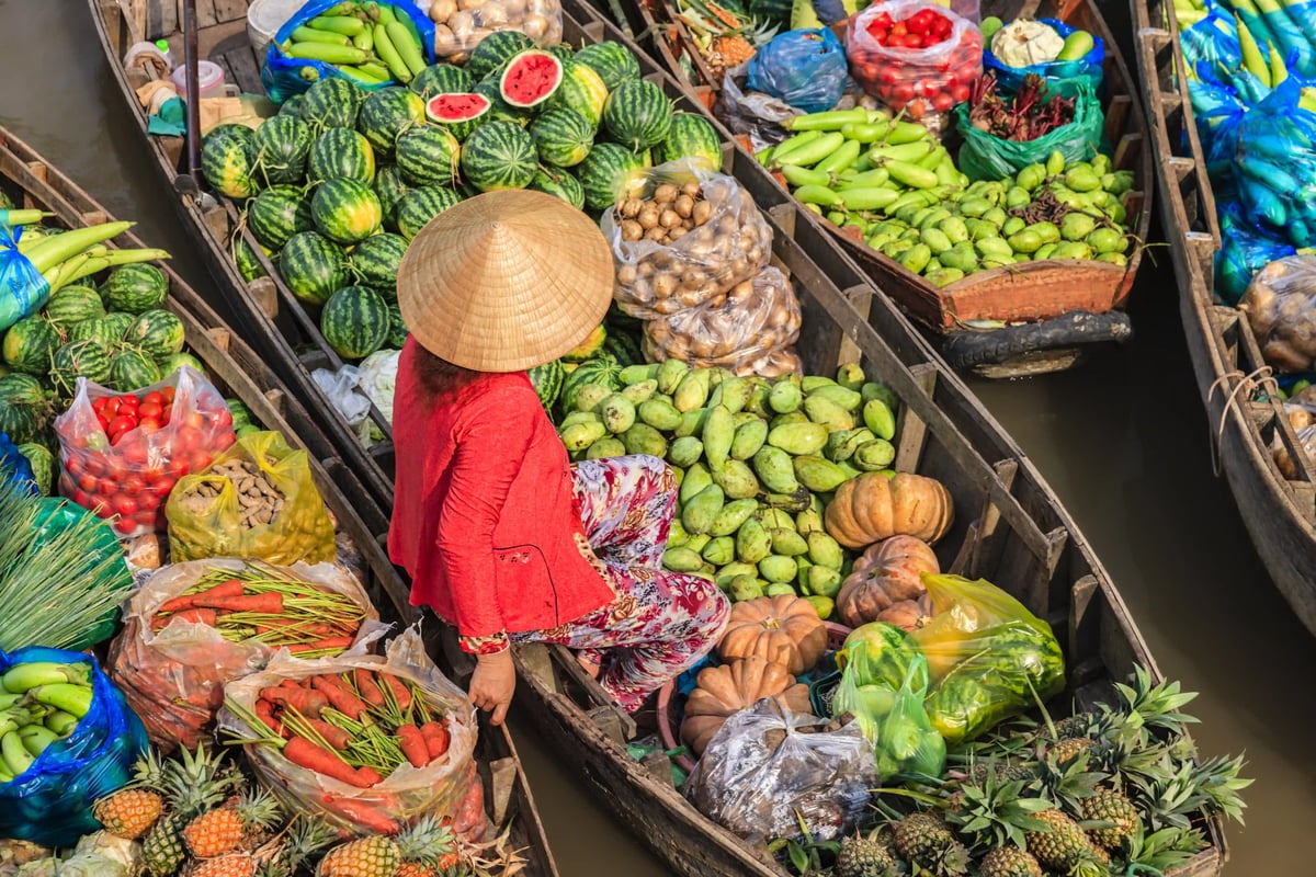 Schwimmender Markt im Mekong Delta mit Booten voller Obst und Gemüse