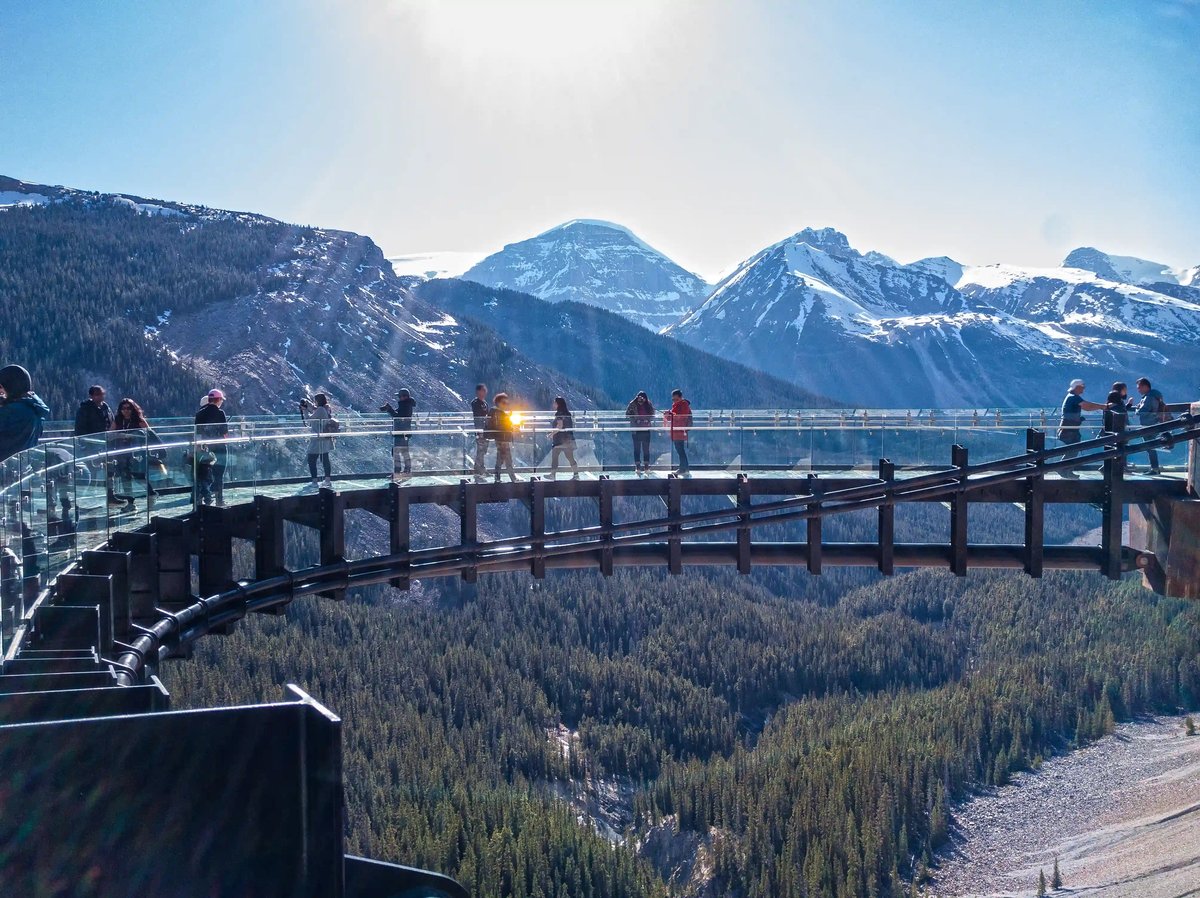 Gläserner Skywalk mit Besuchern hoch über einem Tal in den kanadischen Rocky Mountains