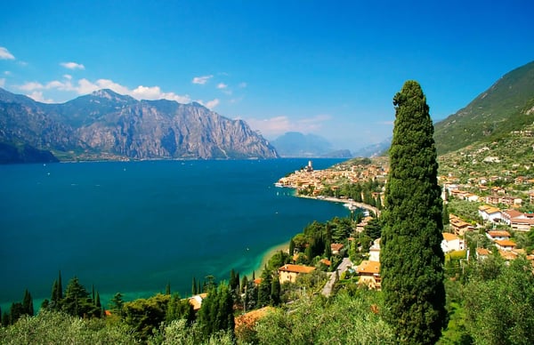 Blick auf Malcesine am Gardasee mit Uferpromenade, See und alpiner Berglandschaft