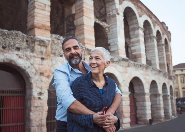 Paar steht umarmt vor den historischen Bögen der Arena di Verona
