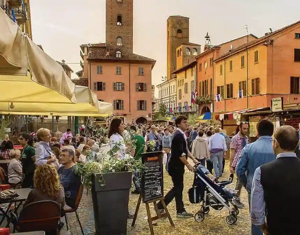 Belebter Marktplatz in Alba mit Besuchern, Ständen und historischen Gebäuden während der Trüffelmesse