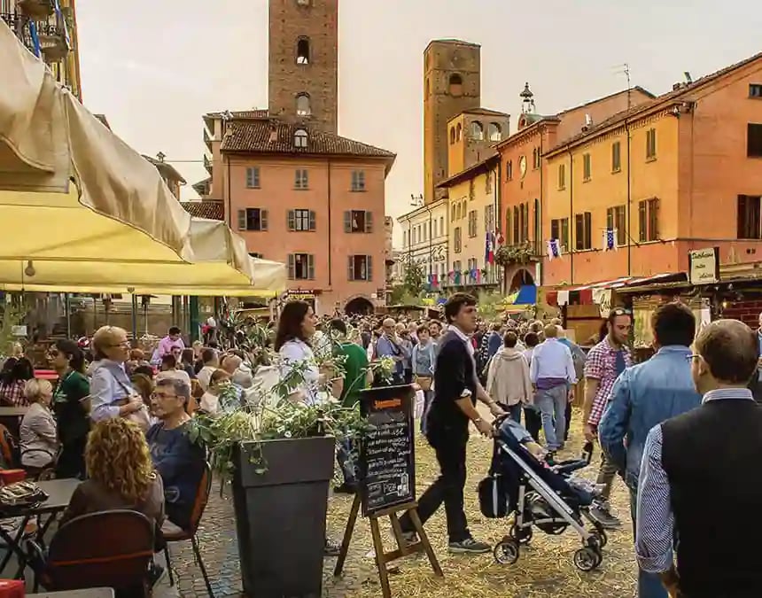 Place animée à Alba avec visiteurs, stands et bâtiments historiques lors de la foire à la truffe