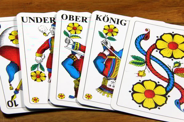 Jasskarten mit Figurenkarten auf einem Holztisch