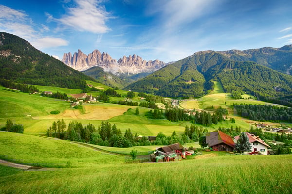 Weite Almlandschaft im Pustertal mit Bauernhöfen und schroffen Dolomiten