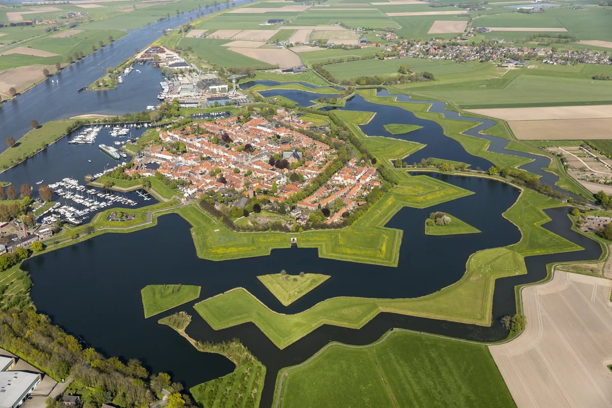 Vue aérienne dune ville fortifiée historique avec douves en forme détoile, toits rouges et paysages verts