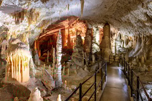 Beleuchtete Tropfsteinhöhle mit Stalaktiten Stalagmiten und sicherem Besucherweg