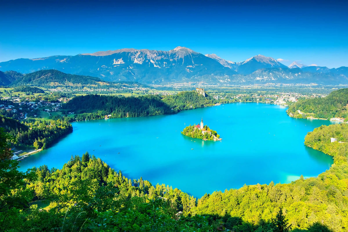 Luftaufnahme der Burg Bled auf einem Felsen über dem türkisfarbenen Bleder See