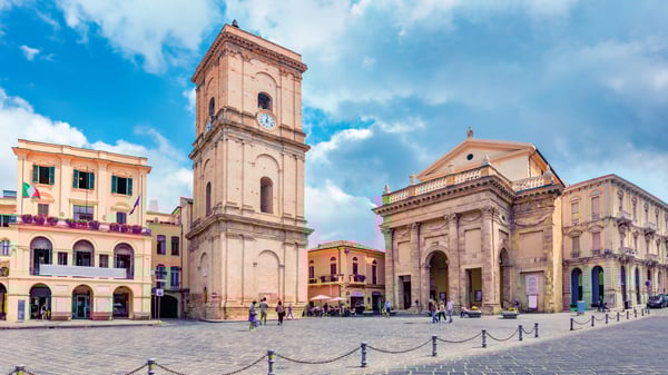 Zentraler Platz in Lanciano mit Kirchturm, historischen Gebäuden und Menschen bei sonnigem Wetter