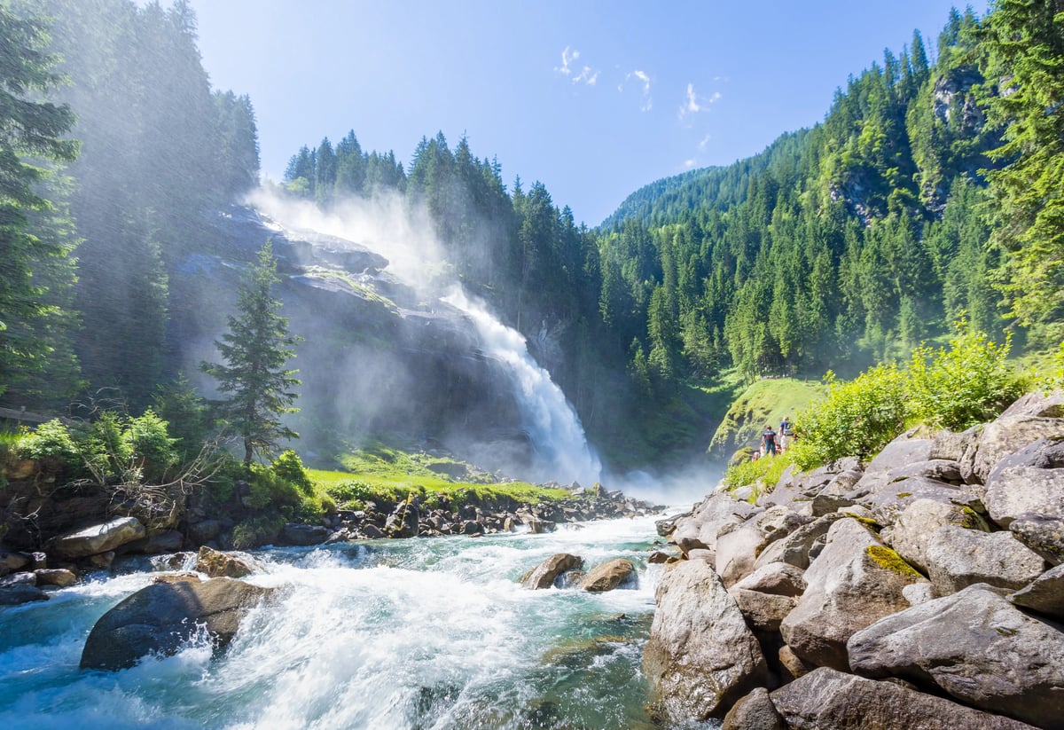 Cascade en paysage alpin avec rivière, rochers et forêt