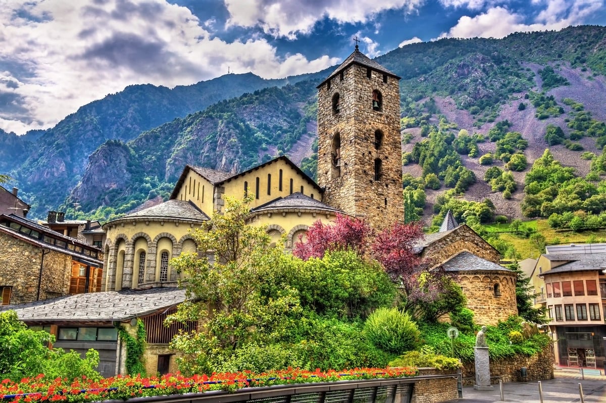 Romanische Kirche in Andorra mit Steinturm vor grüner Bergkulisse