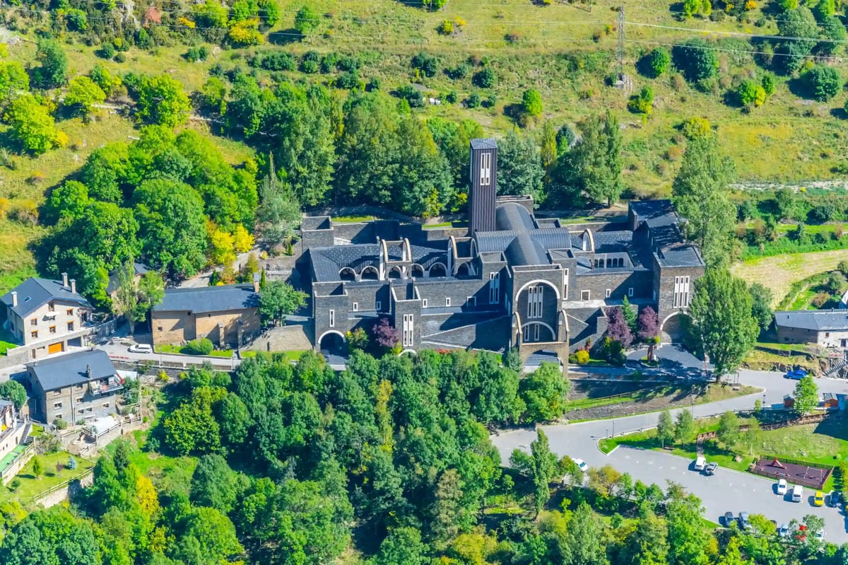 Blick auf das moderne Kloster Meritxell in Andorra inmitten grüner Hügellandschaft